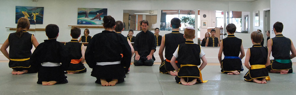 Sifu is in front of a Wushu students, everyone sitting in seiza (feet tucked under them).